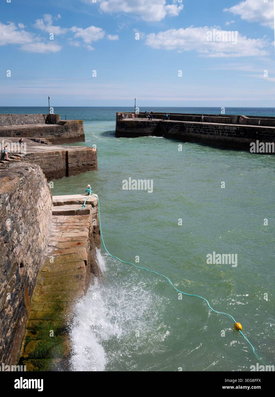 Vagues freinant à l'intérieur des murs de pierre du port de Charlestown, un port de pêche pittoresque près de St Austell sur la côte sud de Cornouailles, en Angleterre. Banque D'Images