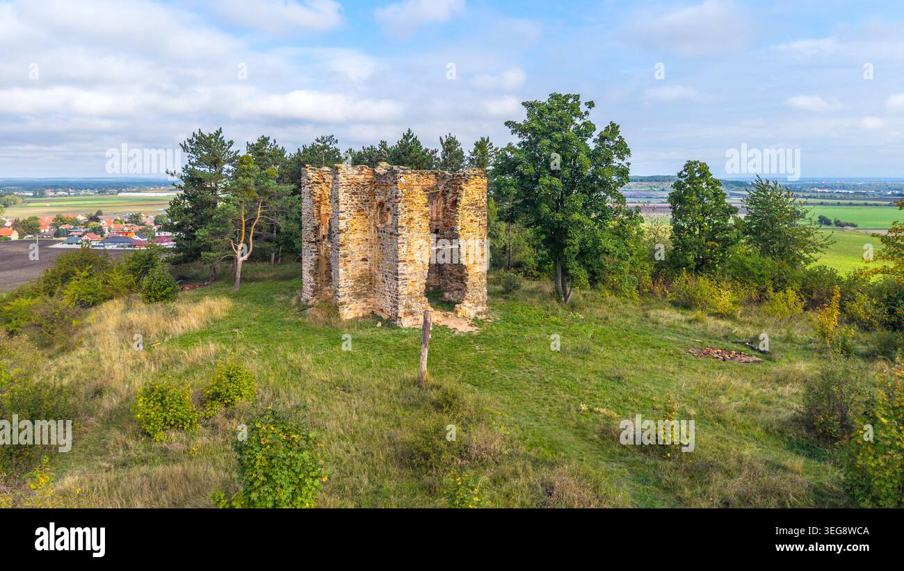 Vue aérienne des ruines de la chapelle de l'exaltation de la Sainte Croix à Bristev. Entourés d'herbe et d'arbres, les restes se dressent sur une colline avec un paysage en arrière-plan. Banque D'Images