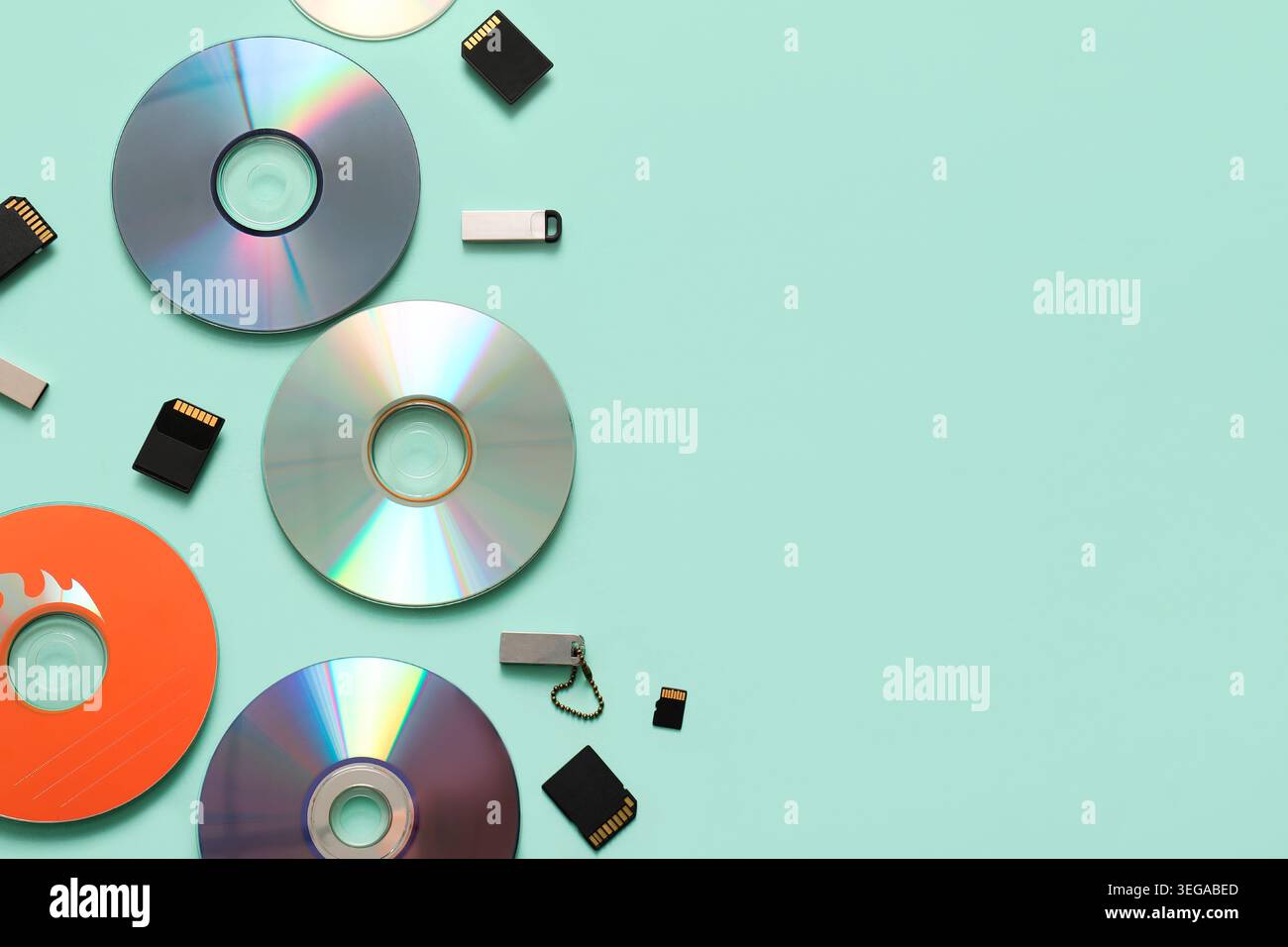 Composition avec disques CD, clés USB et cartes SD sur fond turquoise Banque D'Images