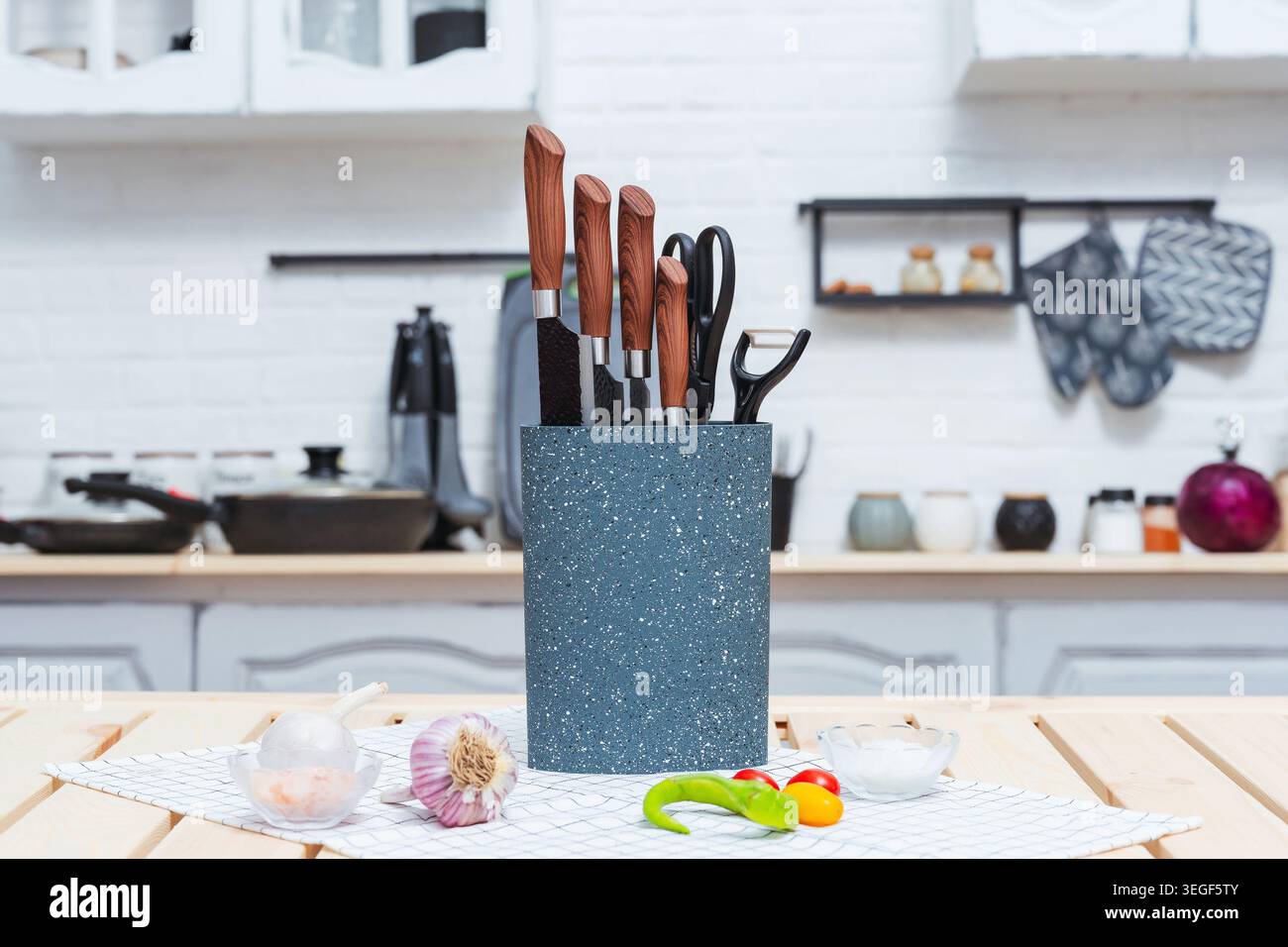 Conteneur de couteau moucheté coloré avec poignées en bois et outils culinaires assortis Banque D'Images