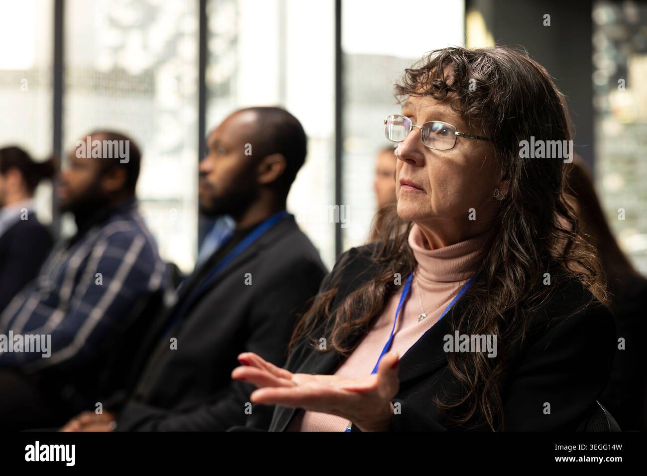 Femme âgée étant confuse et mal comprise le pitch pendant l'événement, en prêtant attention à la présentation dans la salle de conférence. Sommet international de la convention avec des gens d'affaires. Banque D'Images