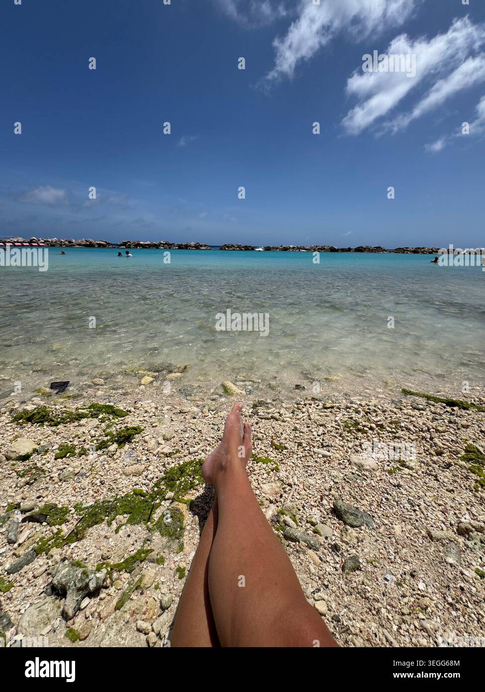 Point de vue photo d'une personne se relaxant sur une plage de sable fin regardant la mer turquoise des Caraïbes à Curaçao - Image de stock capturée avec un smartphone