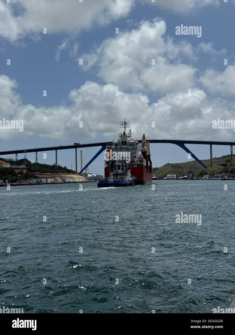 Un grand navire industriel passant sous l'énorme pont Queen Juliana sur le canal du port à Willemstad, Curaçao. Banque D'Images