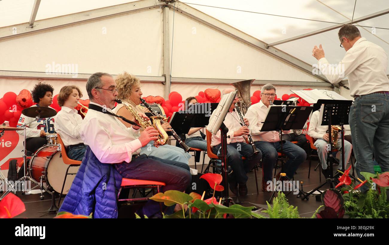 Un orchestre de cuivres local effectuant un concert live sur scène à l'intérieur d'une tente de festival lors d'un événement communautaire au Luxembourg. Banque D'Images
