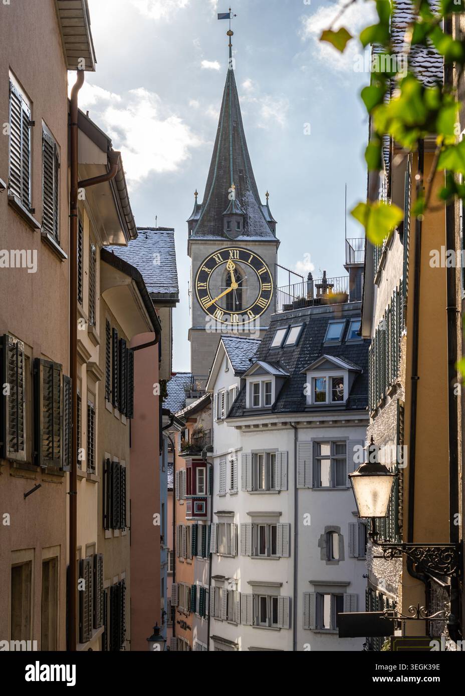 Vue à travers une ruelle étroite vers la grande horloge de la tour de l'église de Pierre à Zurich Banque D'Images
