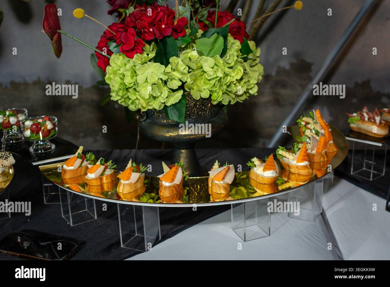 De savoureux canapés ouverts avec des garnitures de viande, d'herbes et de carottes sont élégamment présentés sur un plateau réfléchissant lors d'un buffet de restauration formel Banque D'Images