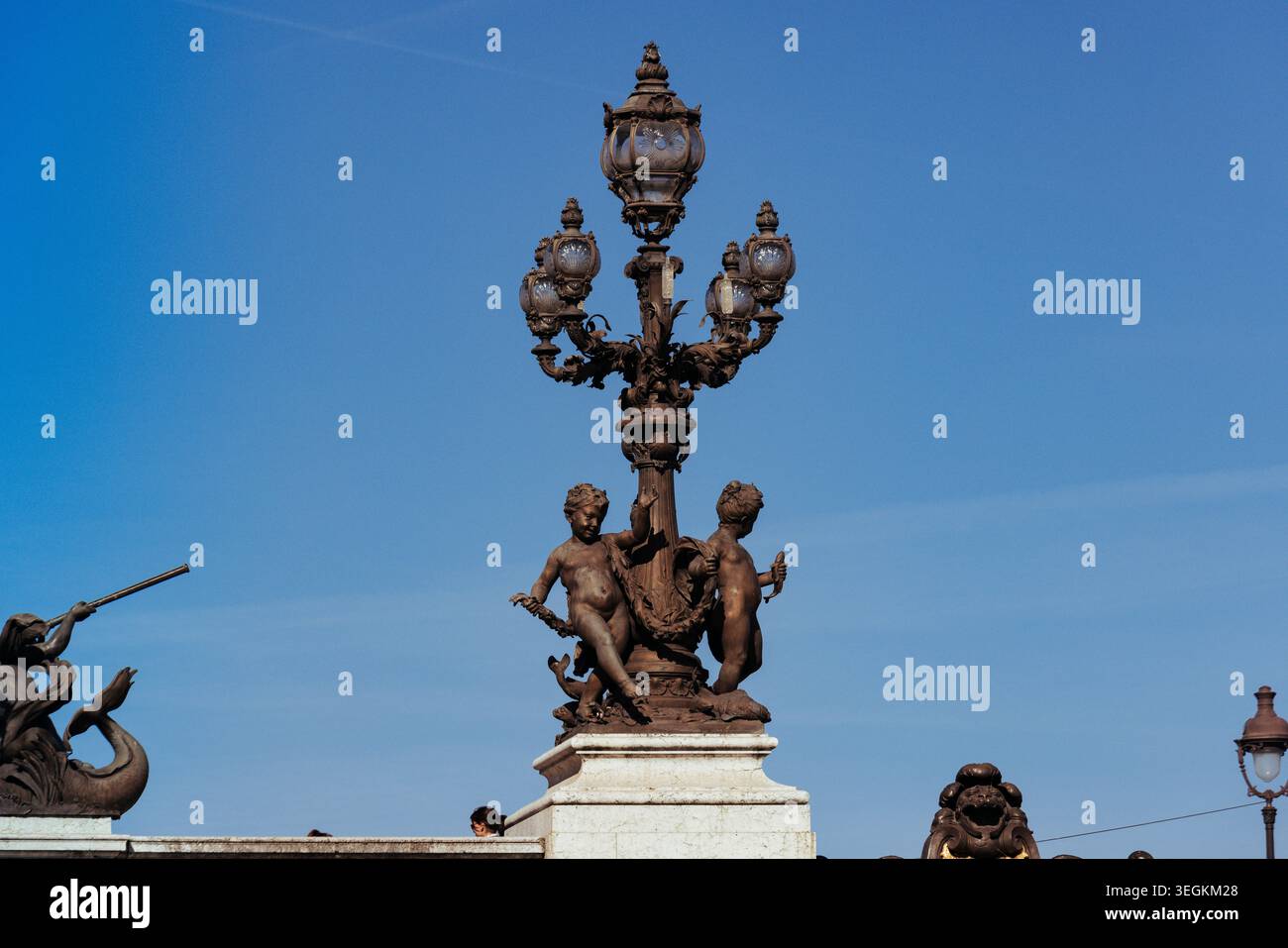 Lampadaire entouré de statues enfantines sur le pont Alexandre III Banque D'Images