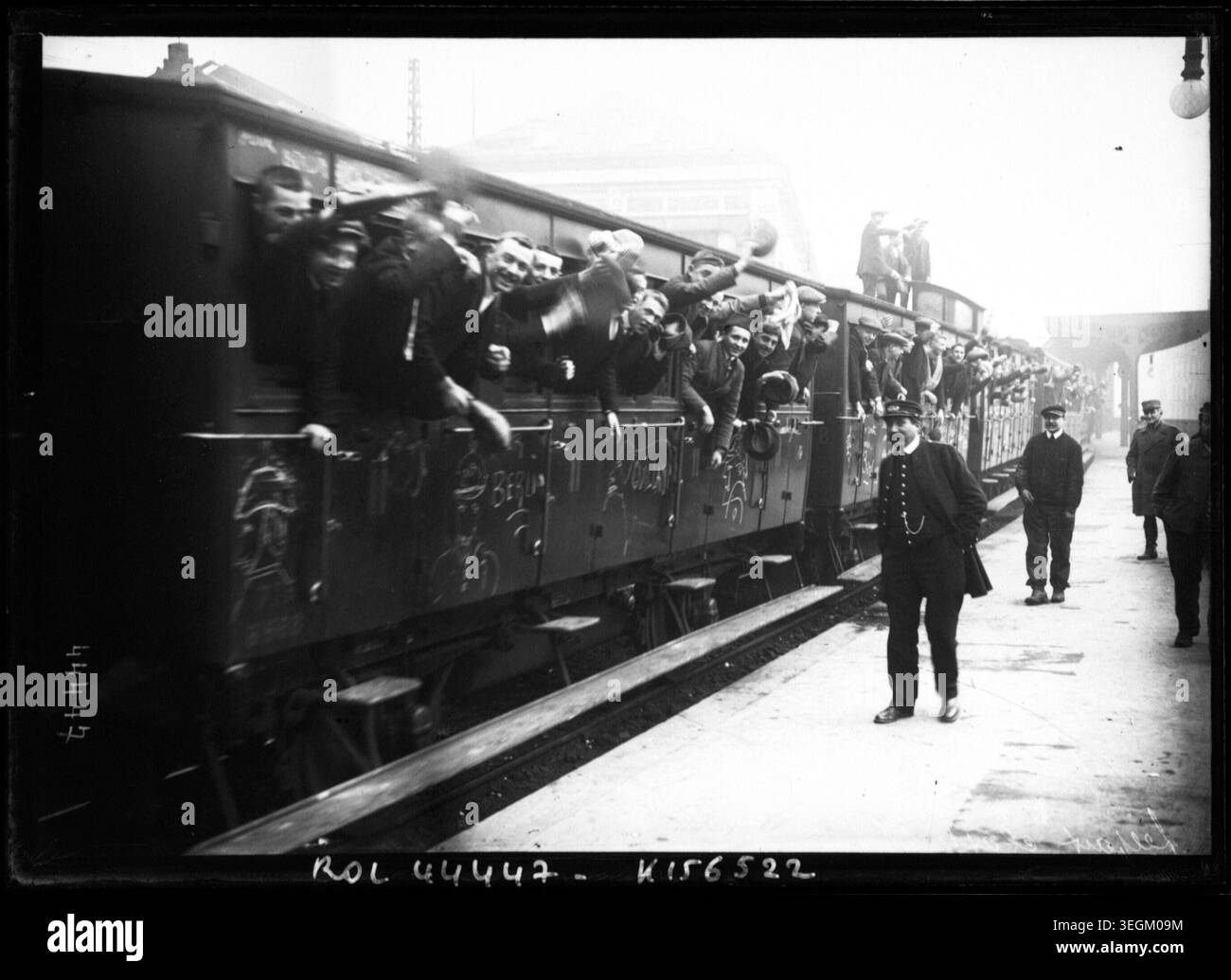 De jeunes hommes se penchent par les fenêtres d'un wagon de train à la gare Montparnasse, Paris, France le 1915 lors de la mobilisation militaire pour la première Guerre mondiale. La photo de presse enregistre le départ des soldats français pour le service. Banque D'Images