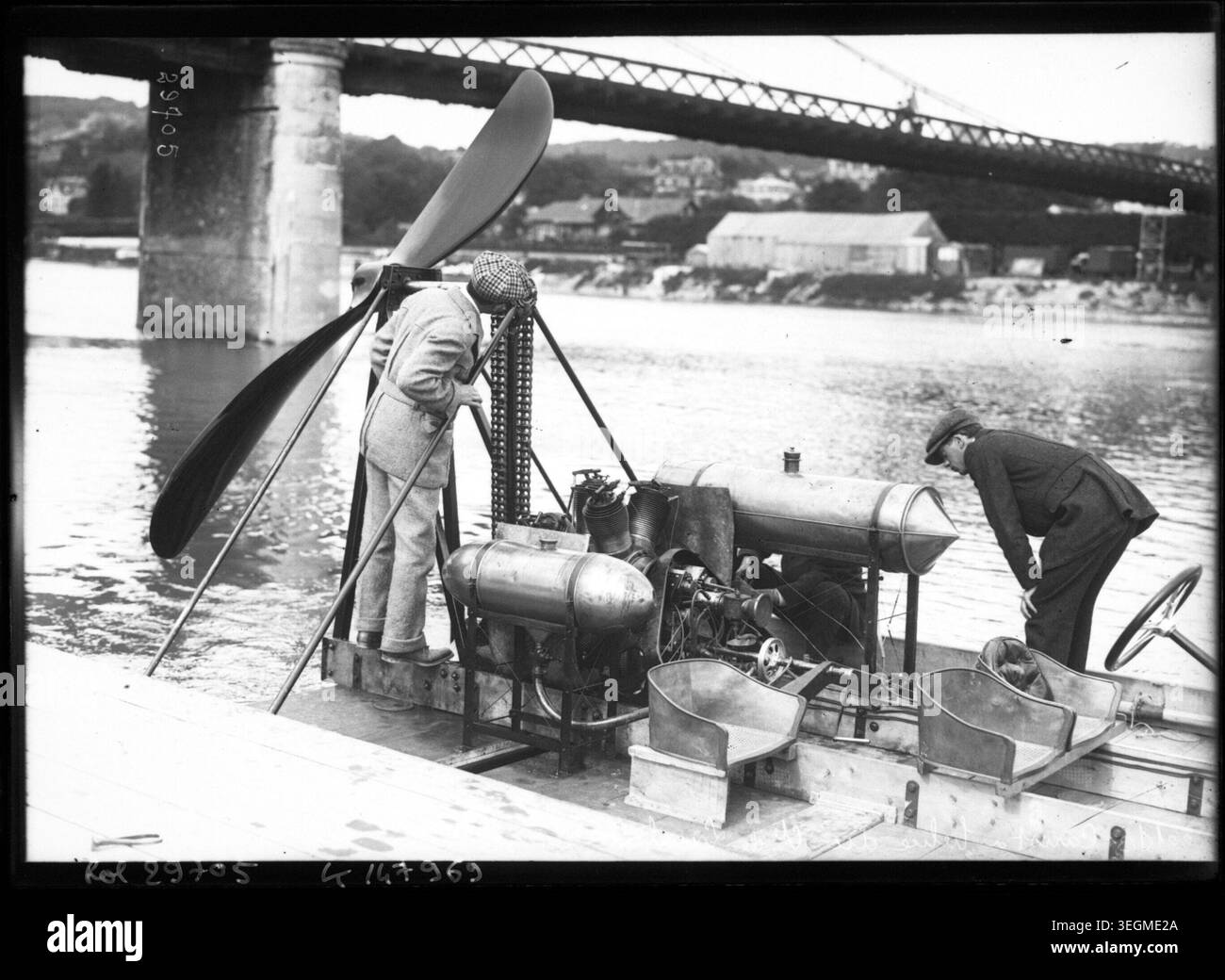 Le comte Charles de Lambert inspecte l'hélice, le moteur et le système de propulsion de son bateau à hélices à Triel-sur-Seine, Yvelines, le 22 mai 1913. La photographie de presse enregistre le bateau, les détails techniques et l'implication de l'inventeur dans la technologie marine. Banque D'Images