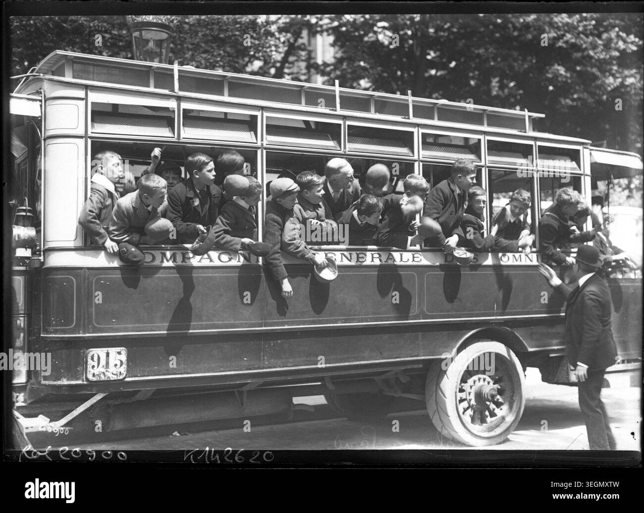 Des enfants anglais montent dans un bus parisien en 1912 lors d’une visite de la ville, accompagnés de tuteurs et d’observateurs dans le cadre d’une excursion organisée, illustrant les visites scolaires internationales et les échanges culturels dans le Paris d’avant-guerre. Banque D'Images