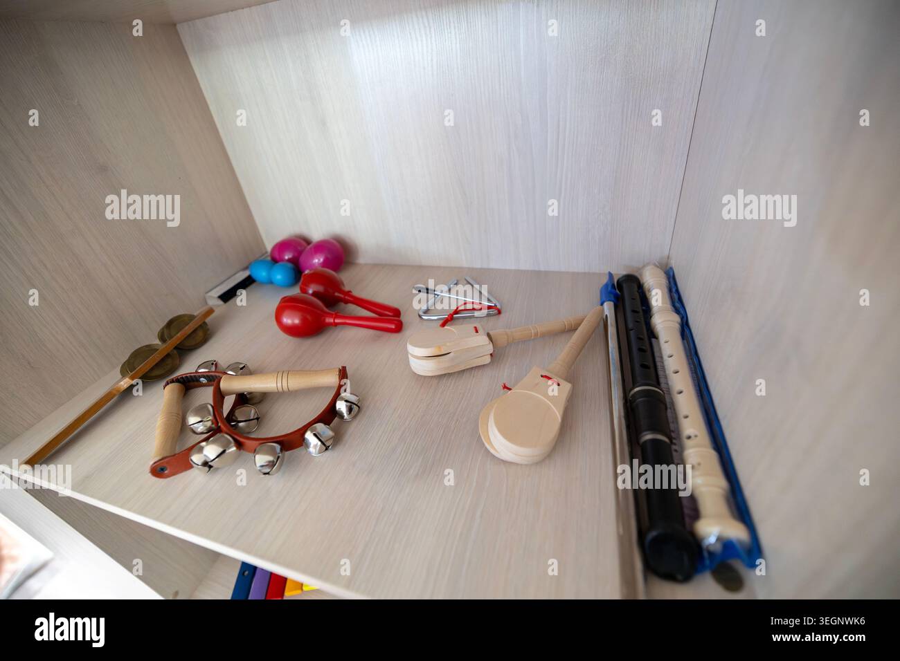 Divers instruments à percussion et à vent pour enfants, y compris des maracas rouges, des cloches à main, des enregistreurs en plastique, des castanets en bois et un triangle métallique l Banque D'Images
