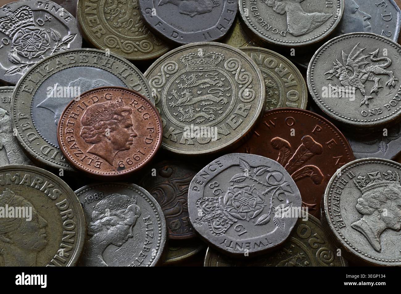 Gros plan détaillé de pièces de monnaie britanniques assorties présentant diverses dénominations et motifs avec des portraits royaux et des symboles héraldiques disposés dans un texte Banque D'Images