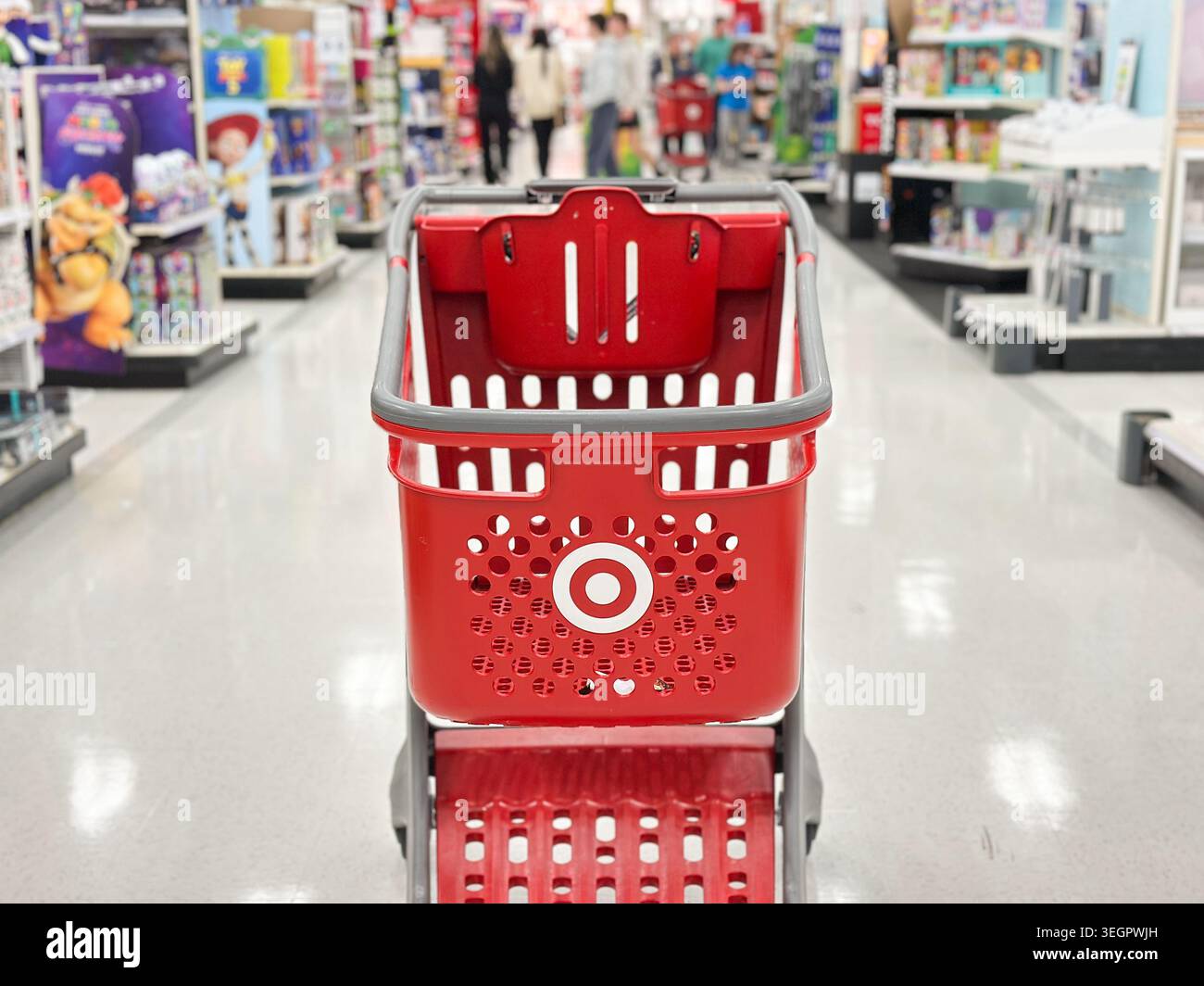 Walled Lake, Michigan, États-Unis - 2 mai 2026 : vue rapprochée d'un chariot rouge Target dans une allée lumineuse d'un magasin de détail avec des acheteurs flous et des marchandises colorées en arrière-plan Banque D'Images