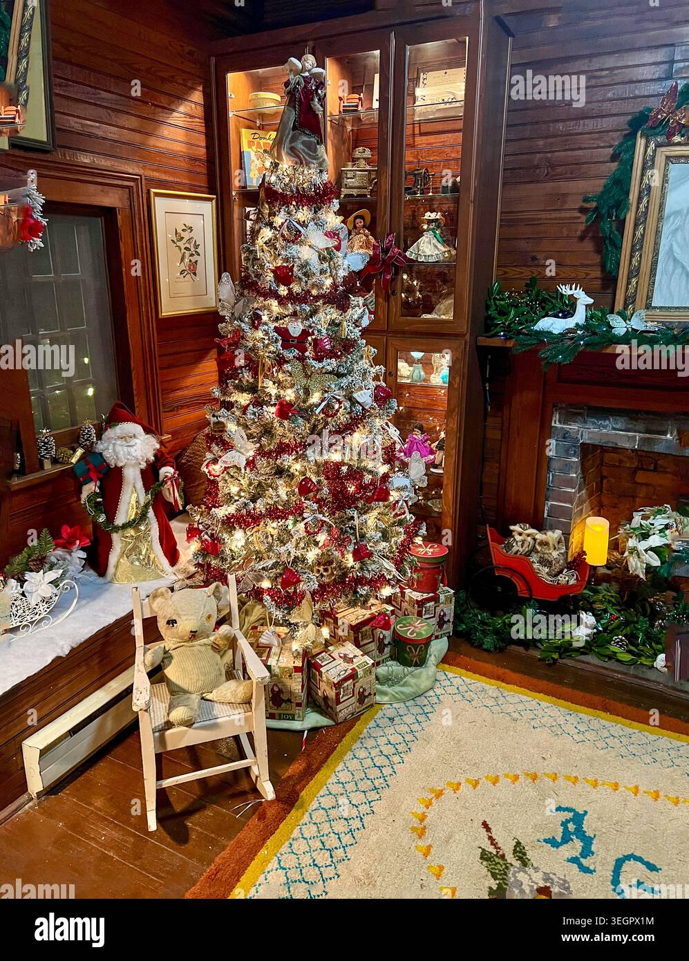 Joyeux arbre de Noël se dresse dans la salle de cabine en bois près de la cheminée à Hopewell Gardens à Aiken, Caroline du Sud. Banque D'Images