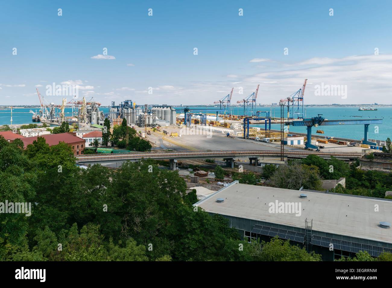 Odessa, Ukraine - 10 juillet 2025 : vue panoramique du port maritime d'Odessa avec un terminal à conteneurs et des grues sous un ciel partiellement nuageux Banque D'Images