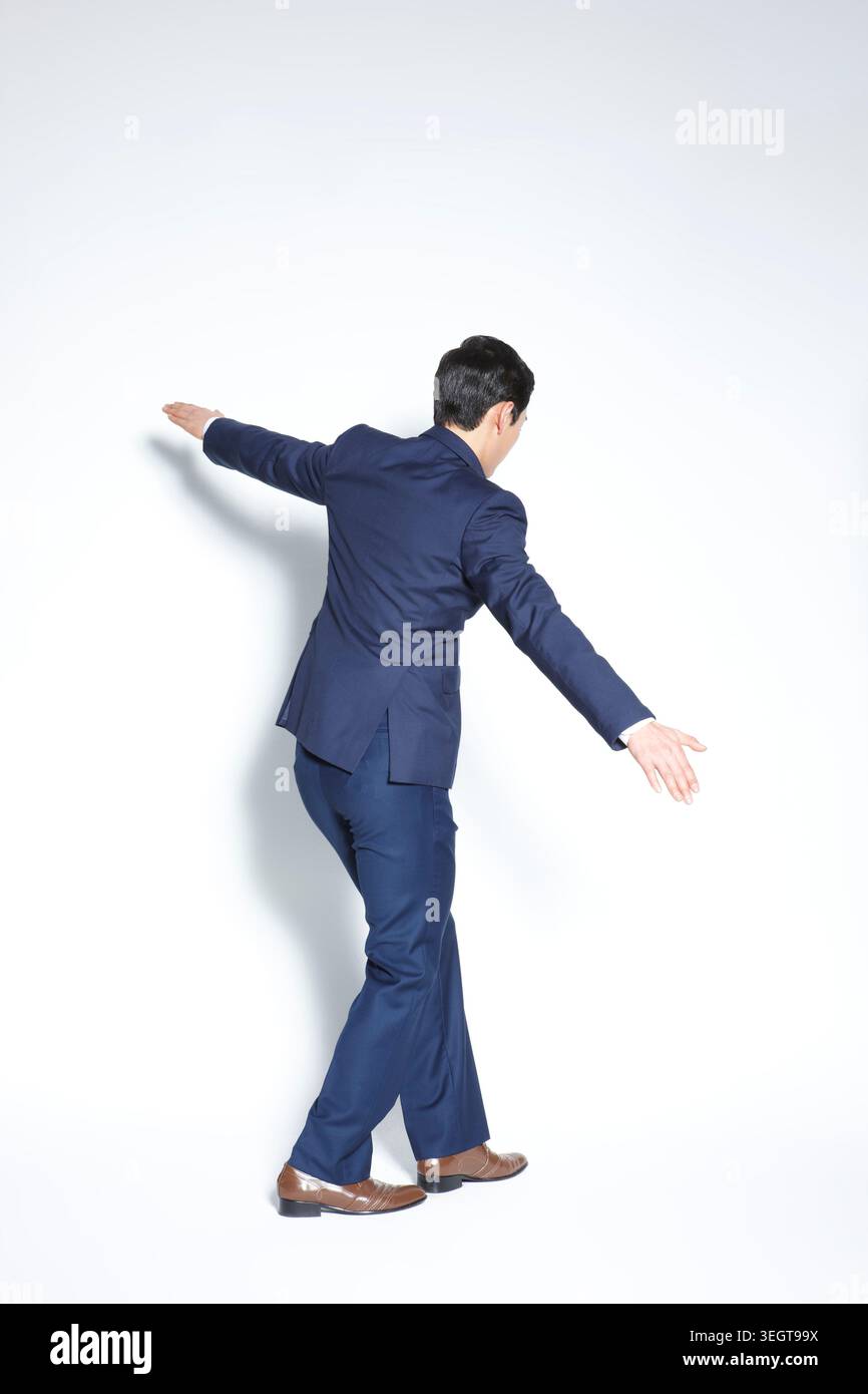un homme d'affaires en costume bleu montrant des gestes avec ses mains Banque D'Images