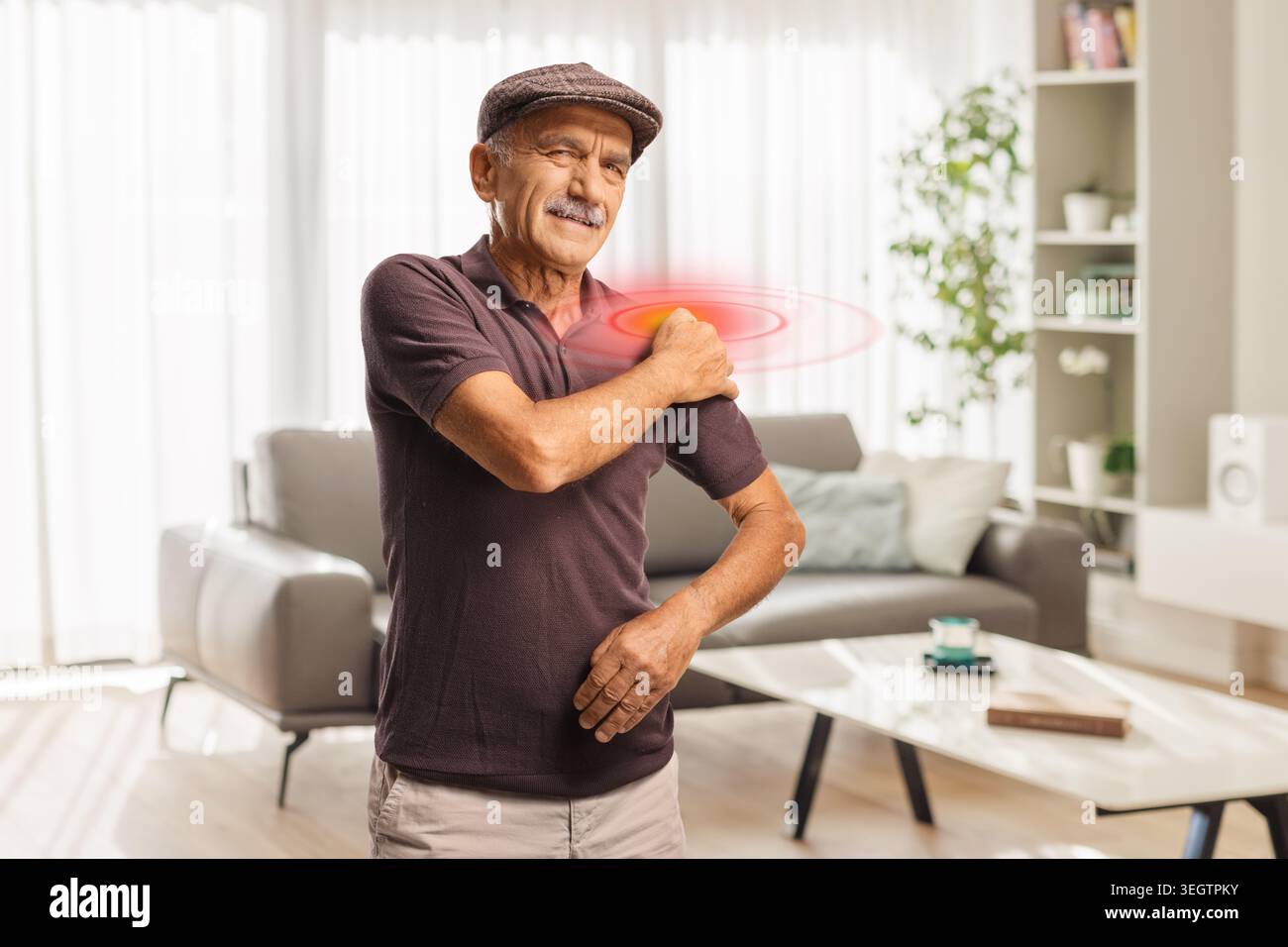 Senior tenant son épaule dans la douleur et l'inconfort à la maison Banque D'Images