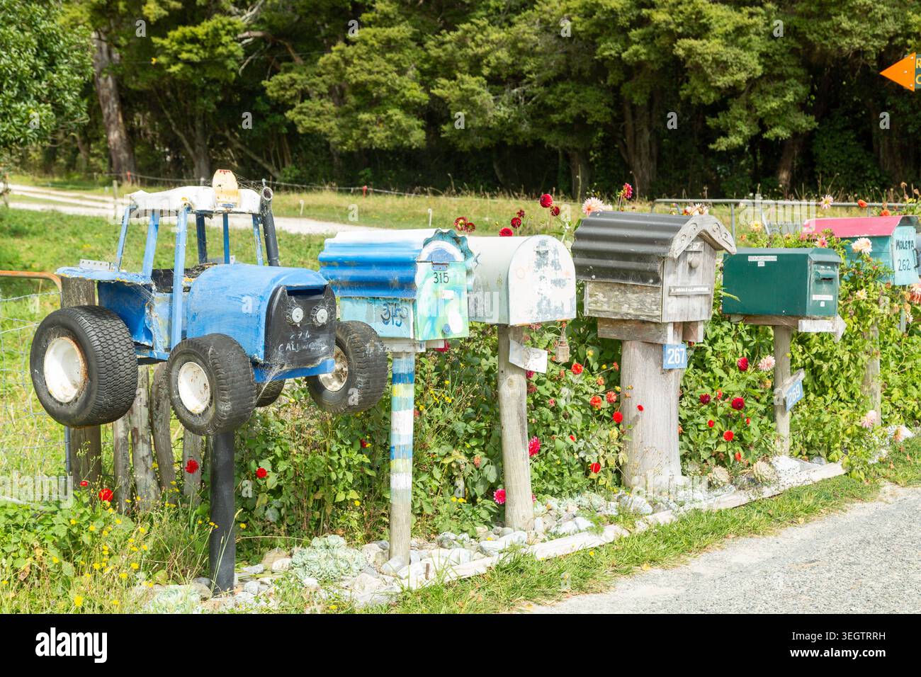 Une collection de boîtes aux lettres rurales comprend une boîte aux lettres unique en forme de tracteur et d'autres en tôle ondulée, Clifton, Nouvelle-Zélande Banque D'Images