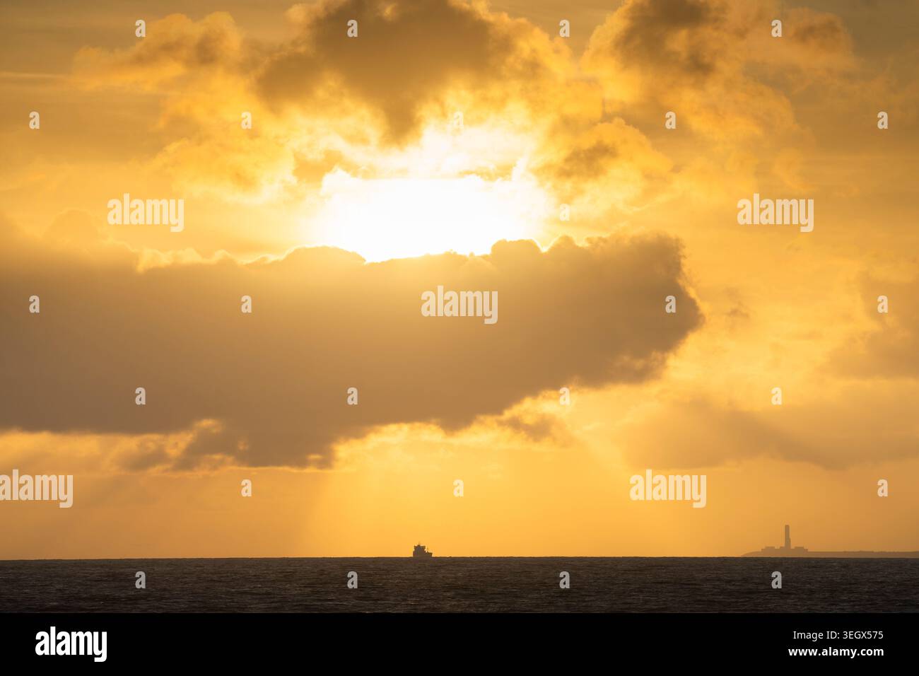Un cargo traversant le canal de Bristol se dessinait au coucher du soleil. Banque D'Images