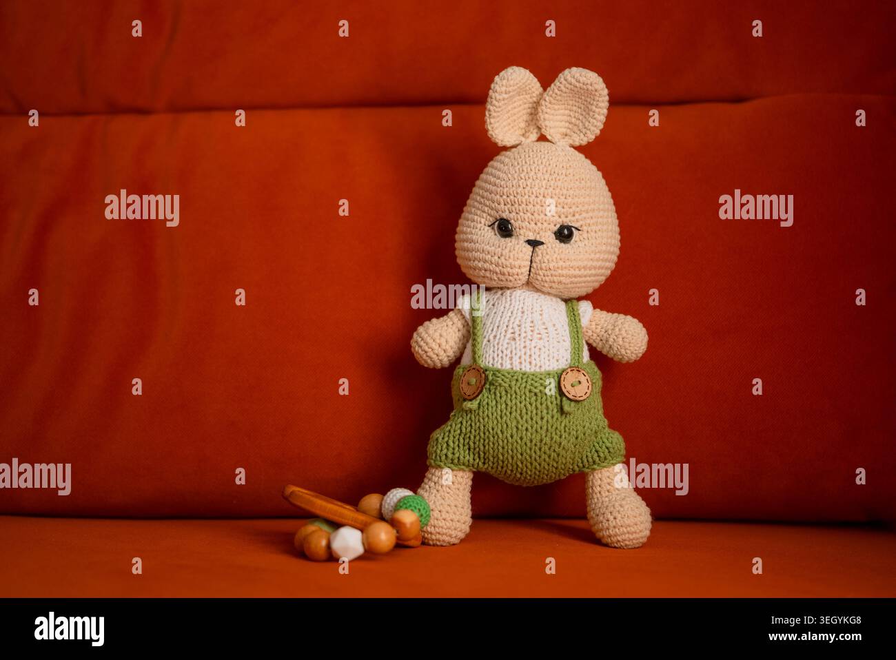 Poupée lapin crochetée avec des boutons en bois et un petit jouet de dentition en bois capturant l'essence de l'artisanat fait à la main, des souvenirs d'enfance, et une atmosphère chaleureuse et accueillante Banque D'Images