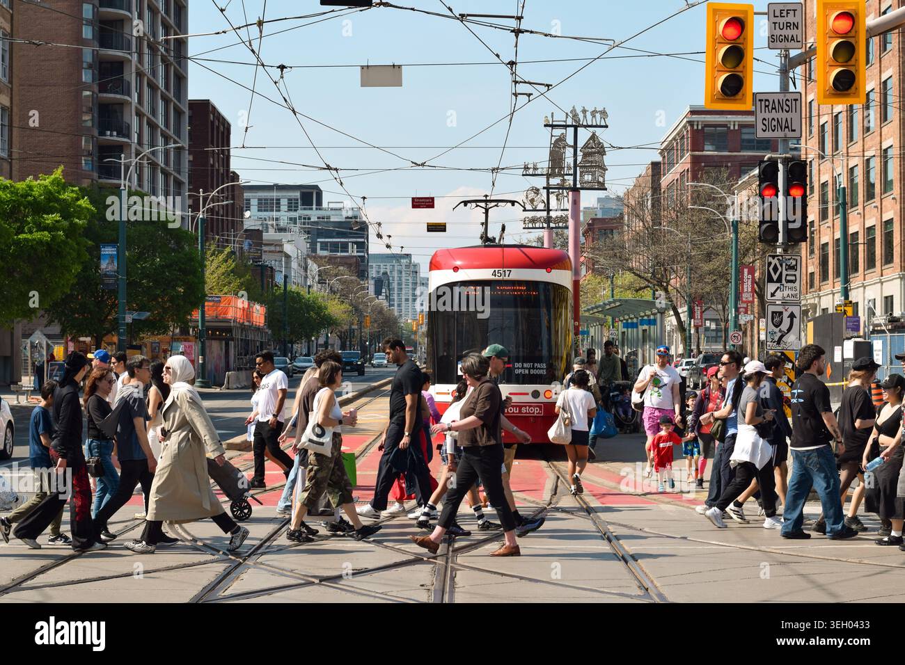 Toronto, Ontario, Canada - 17 mai 2026 : foule de piétons traversant à l'intersection de l'avenue Spadina et de la rue Queen au centre-ville de Toronto avec Banque D'Images