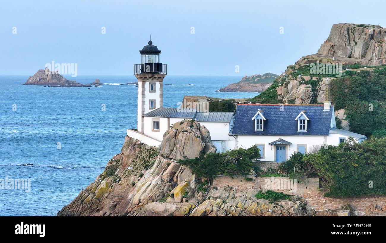 Vue aérienne de l'île Louet avec le phare historique et le chalet du gardien perché sur des falaises rocheuses surplombant la baie de Morlaix à Carantec, Br Banque D'Images