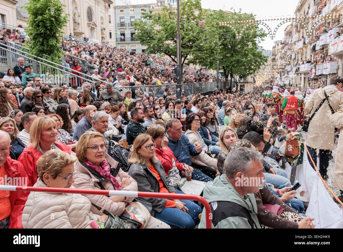 Grande foule de spectateurs assis sur les stands de rue regardant les Maures et les Chrétiens défilent à Alcoy le 25 avril 2026, Espagne Banque D'Images