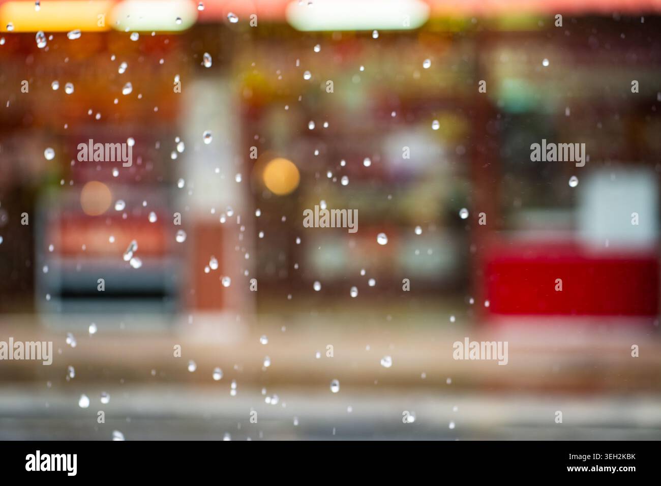 Gouttes de pluie avec fond de ville asiatique floue pendant la saison de mousson. Soft Focus pluie tropicale urbaine, humidité. Temps pluvieux, climat, voyage. Gros plan Banque D'Images
