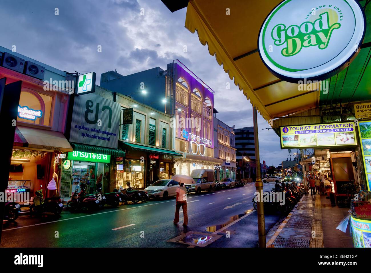 Scène de crépuscule à Phuket Road dans la ville de Phuket, Thaïlande, avec des shophouses illuminées, comme le bâtiment coloré de Top Charoen Opticians' Banque D'Images