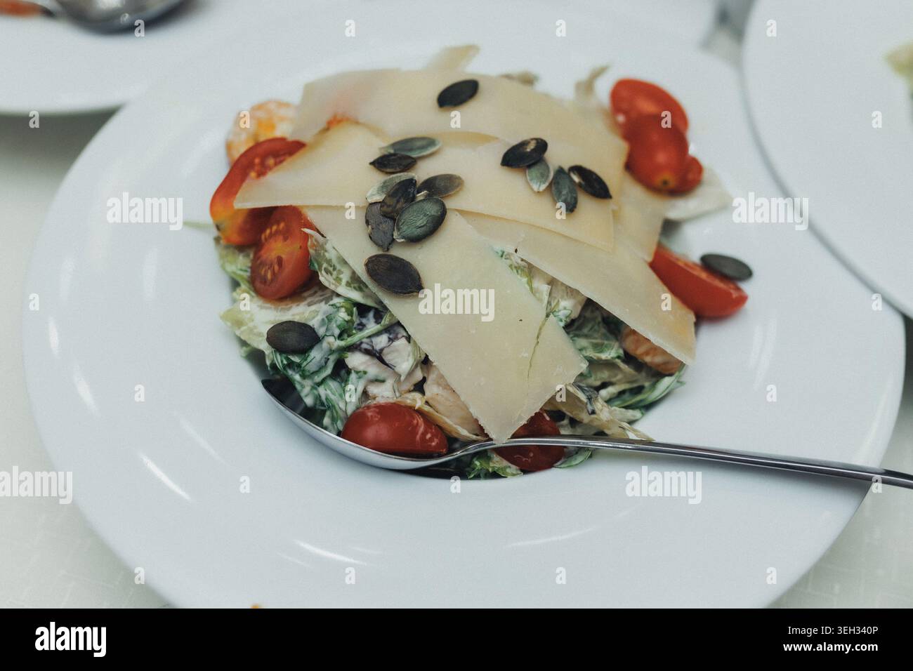 Salade fraîche avec tomates, graines de citrouille et fromage en copeaux Banque D'Images