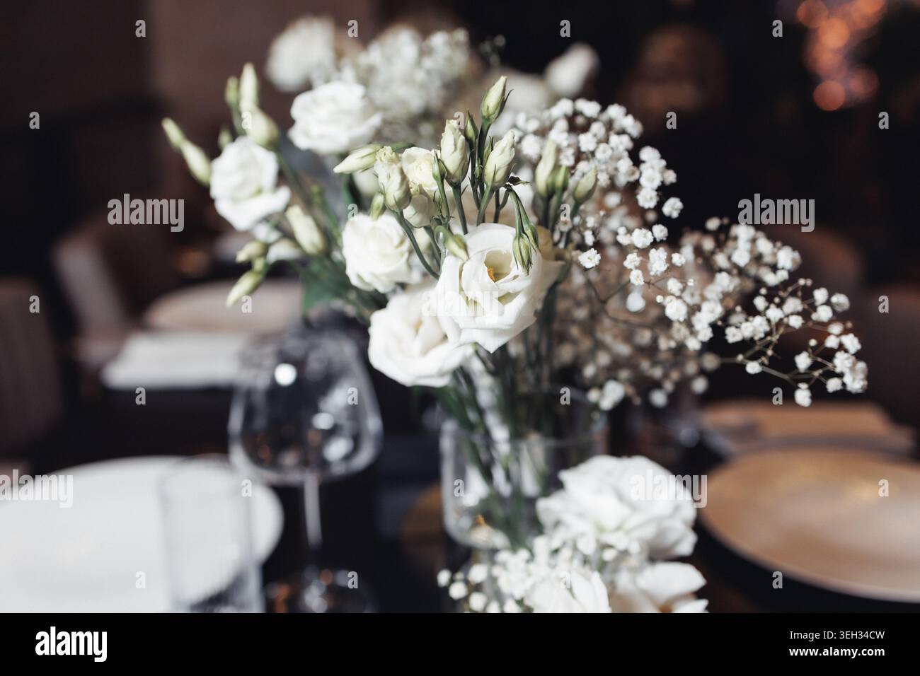 Les roses blanches élégantes et le souffle du bébé fleurissent doucement dans un vase transparent Banque D'Images