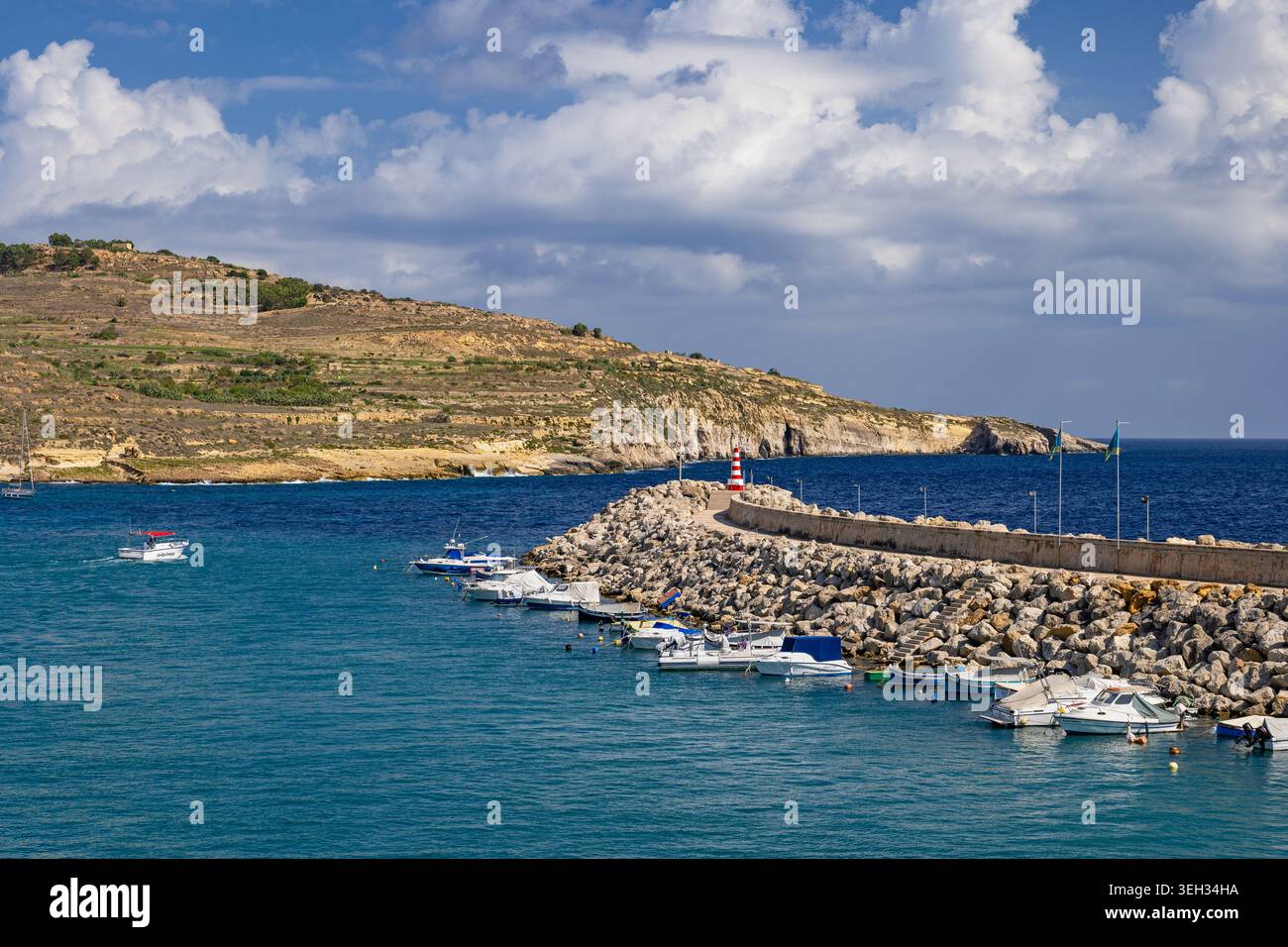 Côte de l'île de Gozo et brise-lames du port avec des bateaux à Malte. Banque D'Images