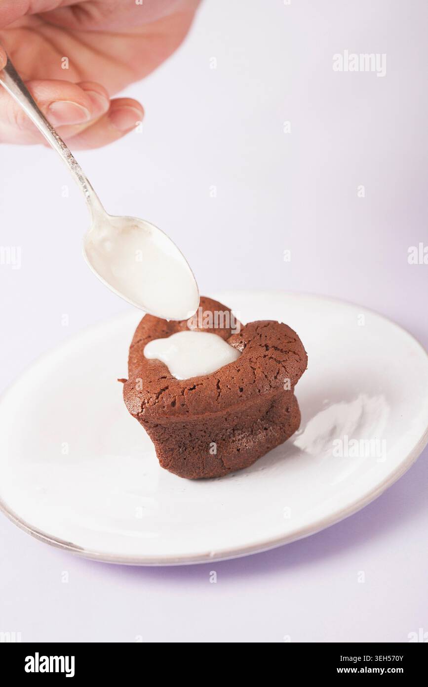 Remplissez le cœur de chocolat fondu en bouche de crème Banque D'Images
