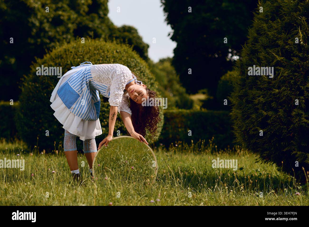 Une belle jeune femme danse librement au milieu d'une verdure luxuriante, incarnant un esprit magique. Banque D'Images