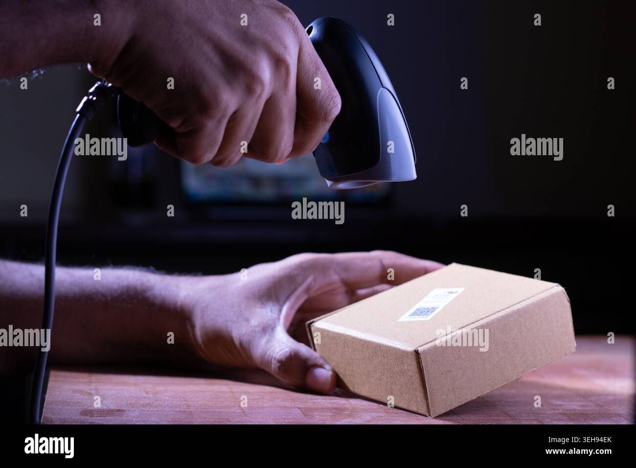 Fermez le scanner de code à barres sur la boîte brune de paquet, inspection des marchandises dans l'entrepôt, le concept de vente de produits dans un supermarché, Spot Focus Banque D'Images