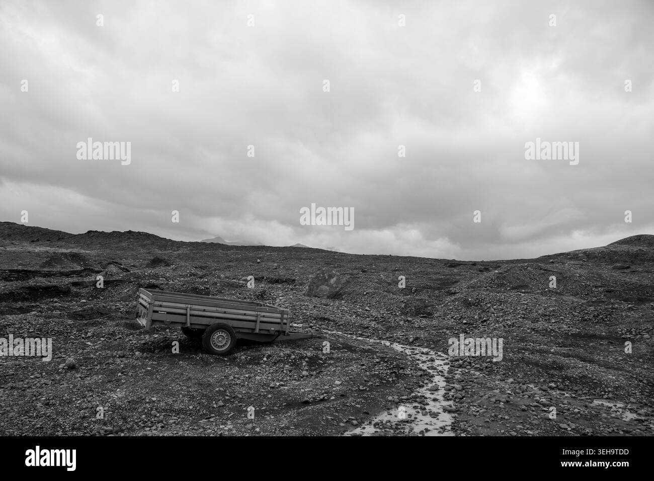 Petite remorque abandonnée sur une lande de cendres volcaniques sous un ciel orageux, atmosphère post-apocalyptique, Islande, en noir et blanc. Petit Banque D'Images