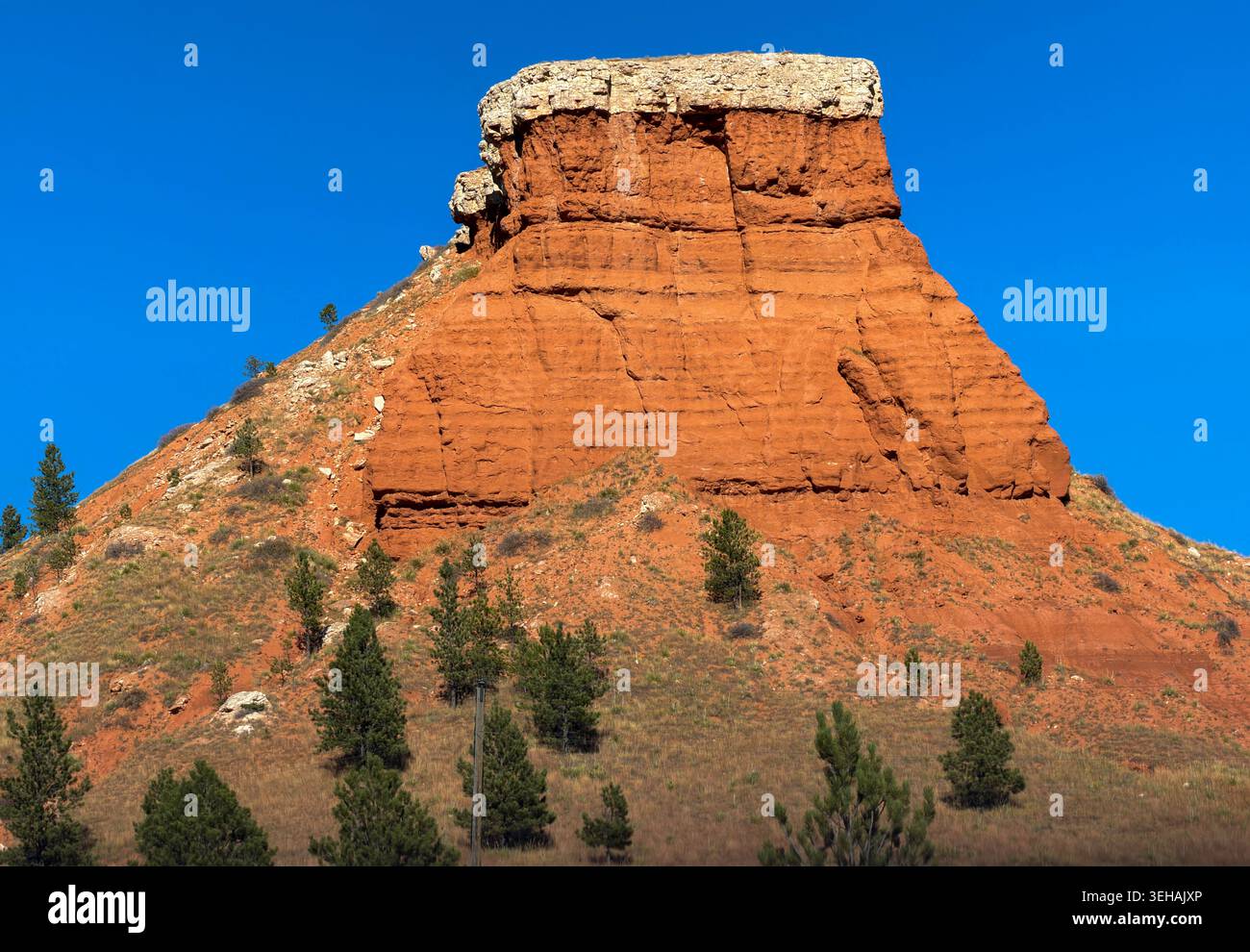 Découvrez Red Butte à New Castle, Dakota du Sud. La formation de grès rouge ressemble à une montagne ou une colline forteresse pyramidale. La roche rouge contraste avec le ciel bleu. Banque D'Images