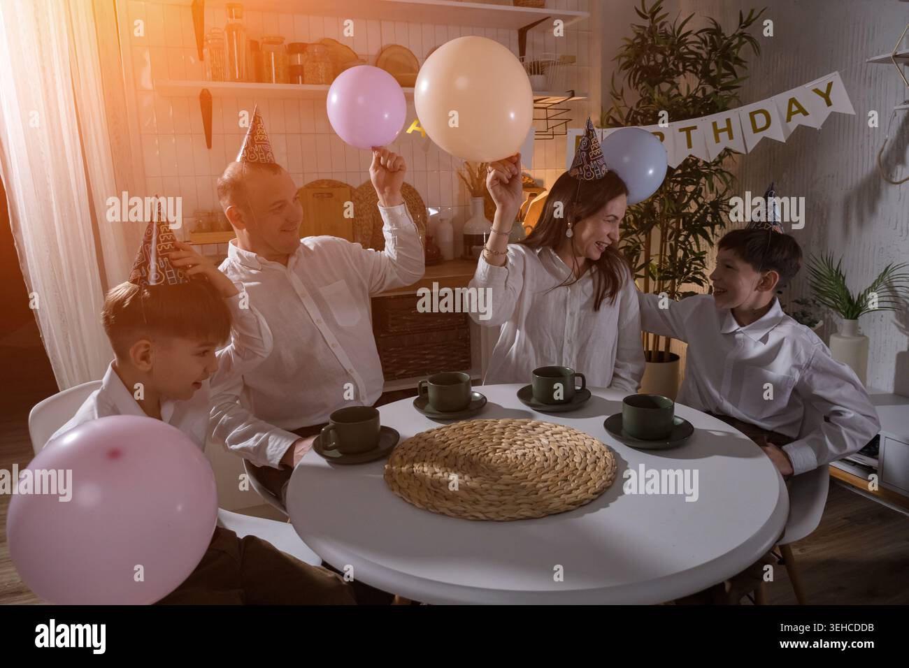 La famille célèbre joyeusement. Joyeuse famille avec ballons célèbre. Famille profitant d'un moment festif avec des ballons colorés. Joyeuse famille environnante Banque D'Images