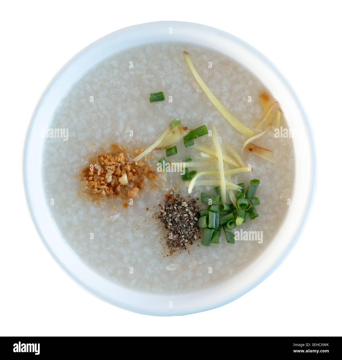 Vue de dessus de la bouillie de riz ou de la soupe de riz ou du riz bouilli avec des épices et de la viande de poulet dans un bol blanc est isolé sur fond blanc avec chemin de découpage. Banque D'Images
