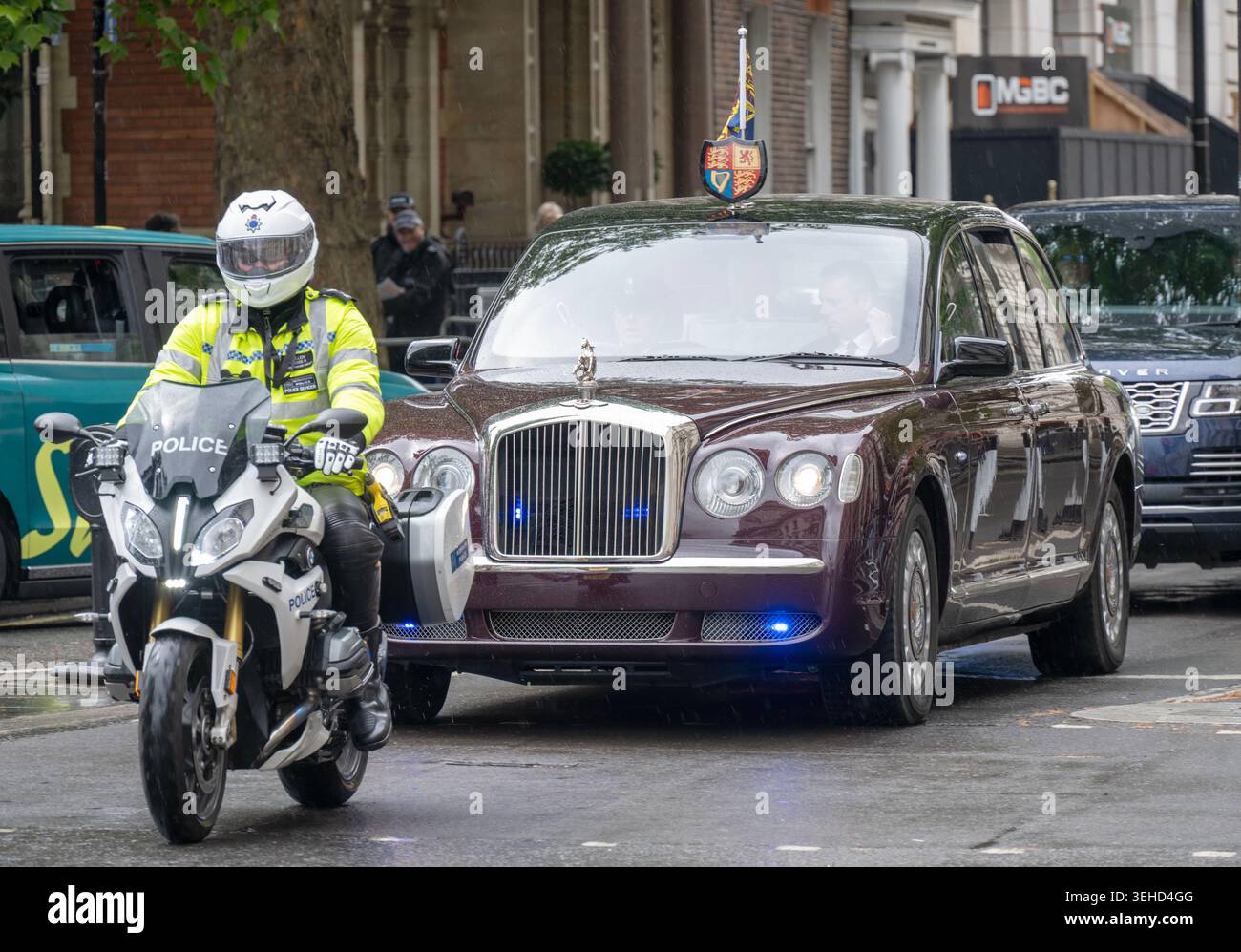 SAR le Roi Charles III conduit à travers Parliament Square, Londres, Angleterre, Royaume-Uni - Bentley State Limousine accompagné d'une moto de police Banque D'Images