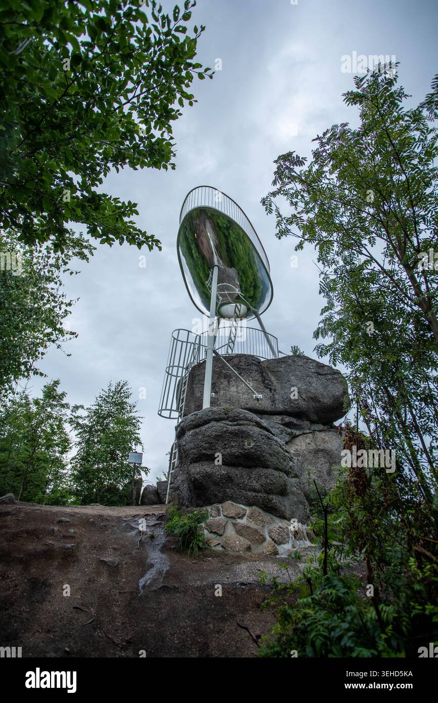 Tour d'observation moderne Spicka avec une grande structure de miroir circulaire debout sur un éperon rocheux entouré de forêt sous ciel nuageux en Tchéquie Banque D'Images