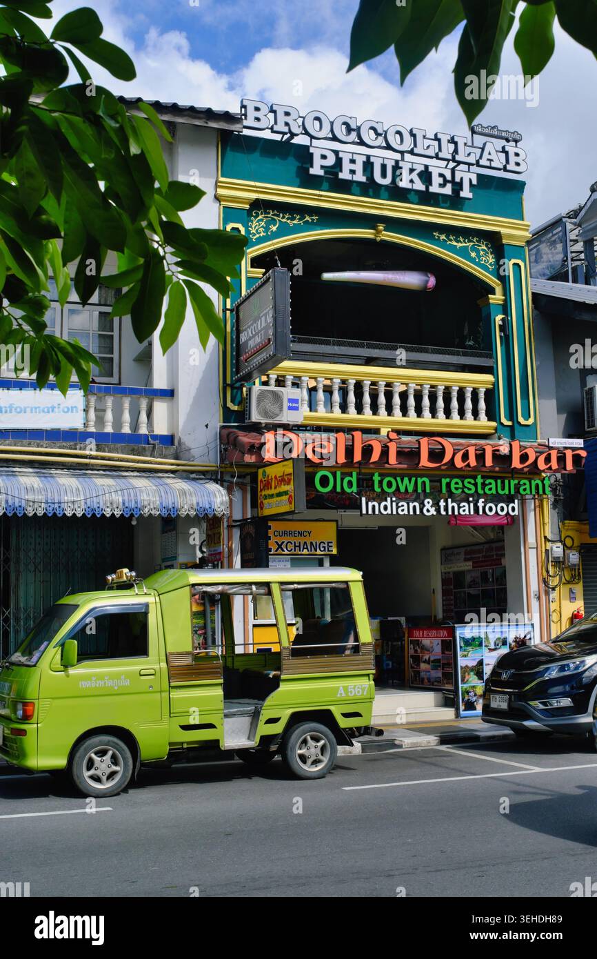 Un tuk-tuk, un taxi local, garé près d'un bâtiment coloré abritant un restaurant indien et un cannabis Bar dans la vieille ville de Phuket Town, en Thaïlande Banque D'Images