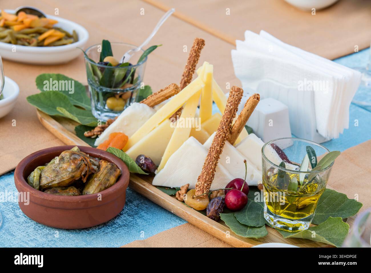 Verre de vin rouge avec un plateau de fromages, cadre gastronomique élégant avec fromages fins, amuse-gueules traditionnels et ambiance détendue du soir Banque D'Images