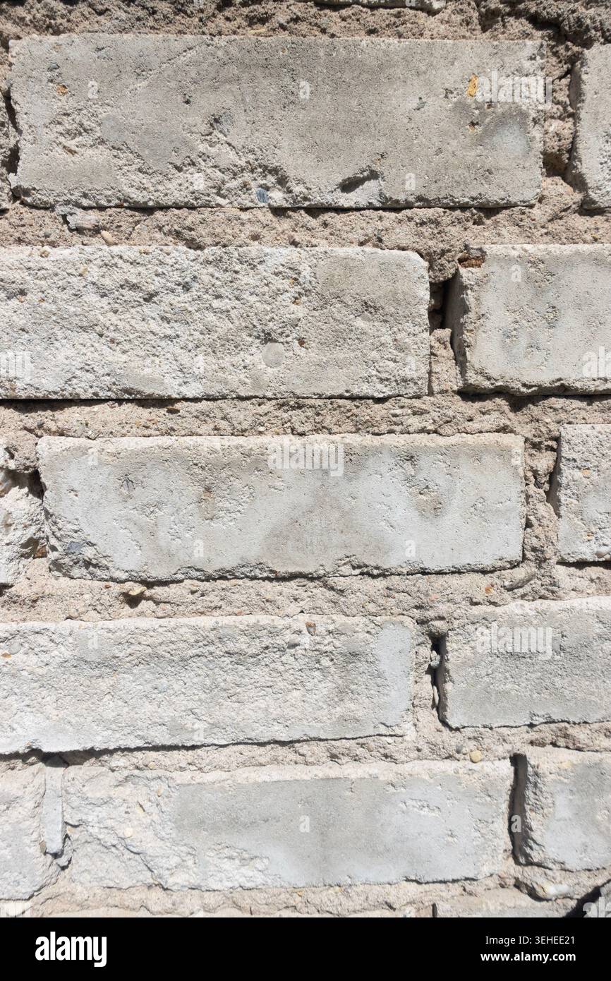 Gros plan d'un vieux mur de briques beiges avec mortier fissuré, texture rugueuse et détail de maçonnerie altérée Banque D'Images