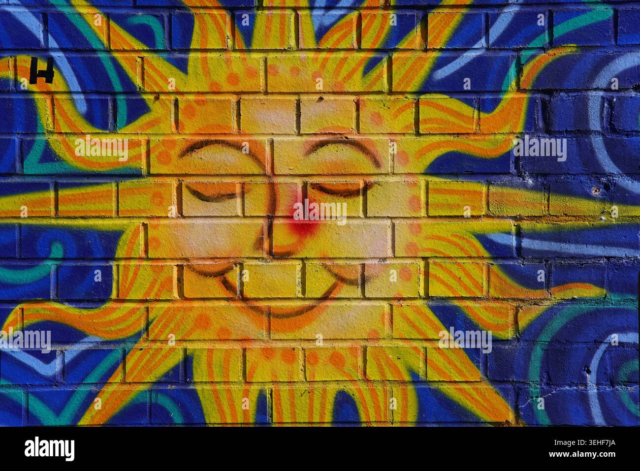 Murale joyeuse et souriante Sun Street art sur un mur de briques à Brighton, en Angleterre. Banque D'Images