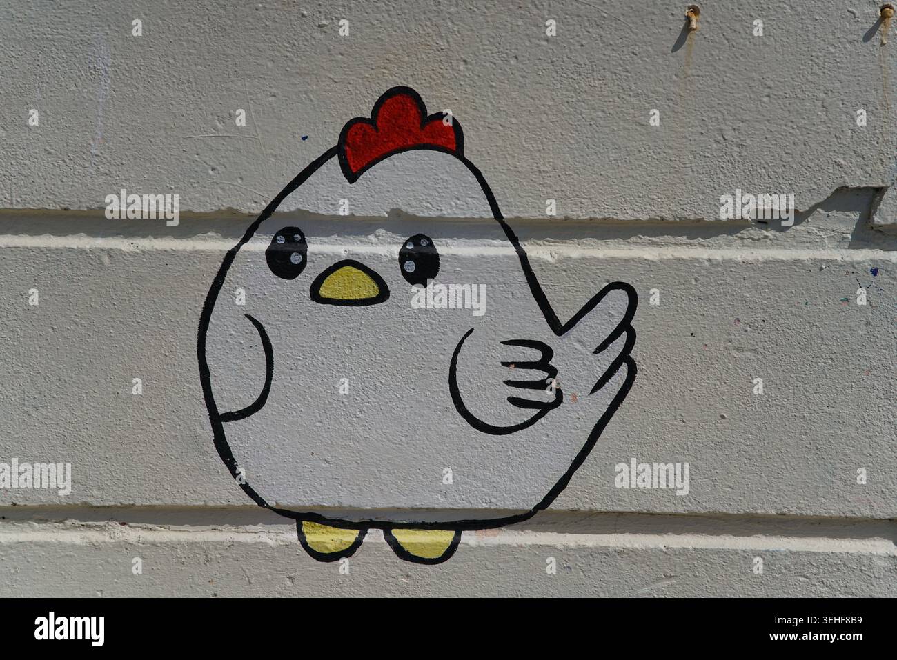 Adorable poulet de dessin animé blanc avec peigne rouge et agitant à la main mignonne peinture murale de Street art de style kawaii peinte sur un mur blanc à Brighton, en Angleterre. Banque D'Images