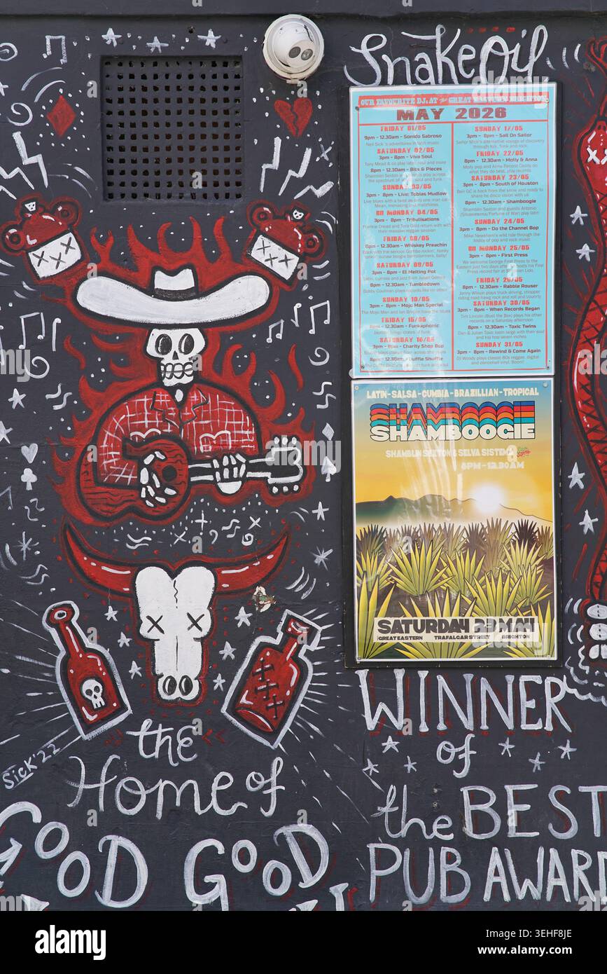 Squelette cow-boy jouant de la guitare 'Snake Oil' avec 'Winner of the Best Pub Award' Street art mural détaillé à Brighton, en Angleterre Banque D'Images