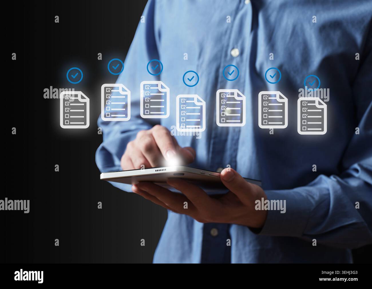 Homme d'affaires utilisant une tablette pour la révision des documents et la gestion des tâches, assurant la conformité avec les listes de contrôle numériques et la vérification Banque D'Images