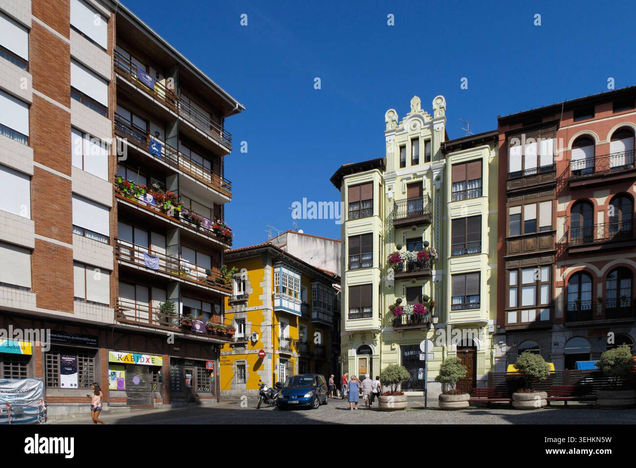 Architecture historique et bâtiments résidentiels modernes entourant une place publique sous un ciel bleu clair à Bermeo, pays Basque, Espagne, Europe Banque D'Images