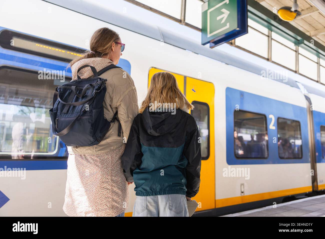 Maman et fille attendent dans une gare d'Amsterdam pendant leurs vacances de printemps aux pays-Bas. Banque D'Images